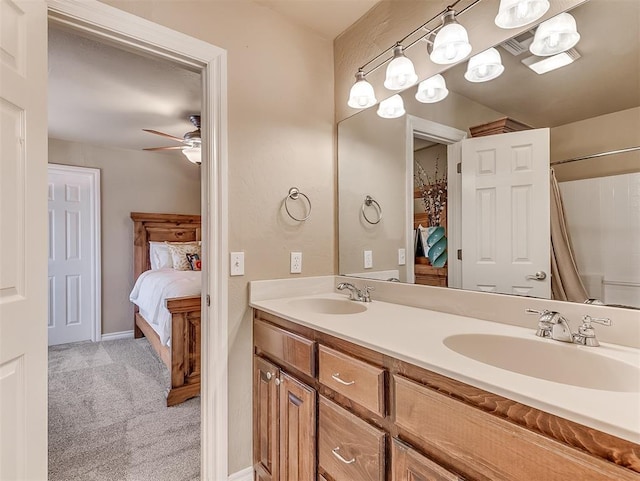 ensuite bathroom featuring ensuite bathroom, double vanity, ceiling fan, and a sink