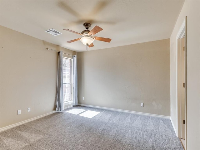 spare room with a ceiling fan, carpet, visible vents, and baseboards