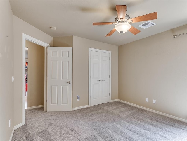 unfurnished bedroom featuring carpet floors, a closet, visible vents, ceiling fan, and baseboards