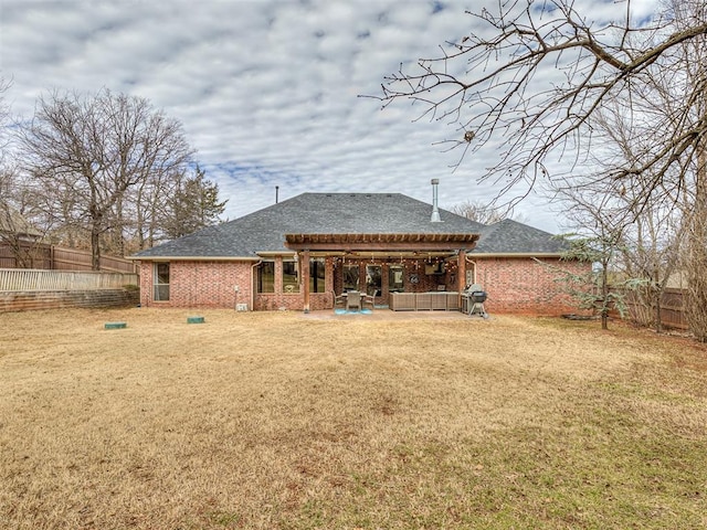 back of house featuring a lawn, fence, a patio, and brick siding