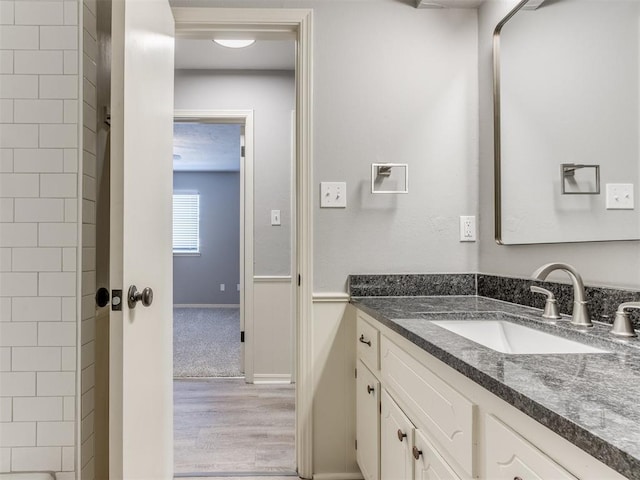 full bathroom featuring a shower, wood finished floors, and vanity