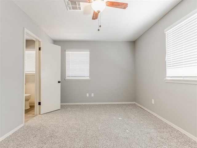 unfurnished bedroom with baseboards, multiple windows, visible vents, and light colored carpet