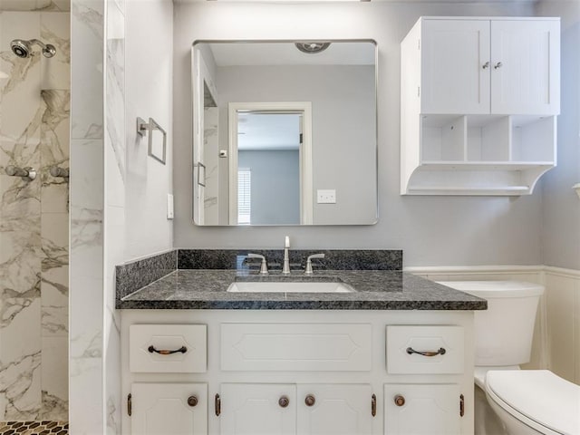 full bathroom with toilet, vanity, and a marble finish shower