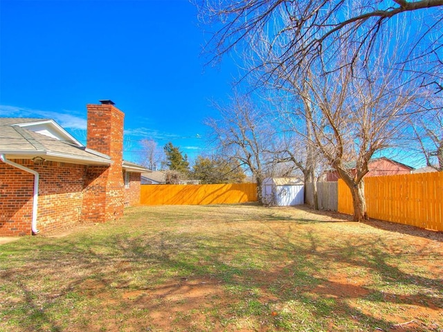 view of yard featuring a shed, an outdoor structure, and a fenced backyard