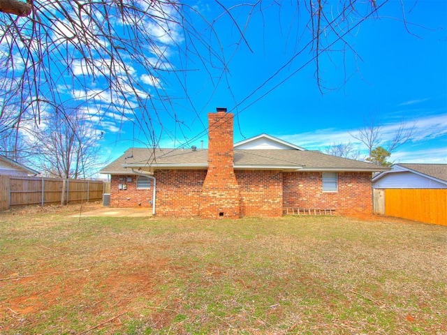 rear view of house with a fenced backyard, a chimney, a patio, and brick siding