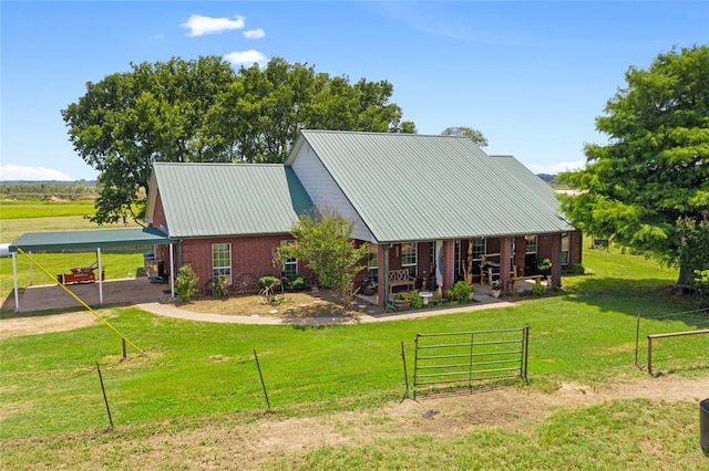 view of front of house featuring metal roof, brick siding, and a front lawn