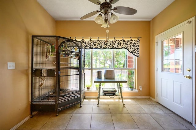 interior space featuring ceiling fan, tile patterned floors, and baseboards