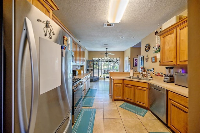 kitchen featuring light countertops, appliances with stainless steel finishes, a sink, and visible vents