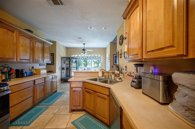 kitchen with stainless steel appliances, light countertops, visible vents, brown cabinetry, and a sink