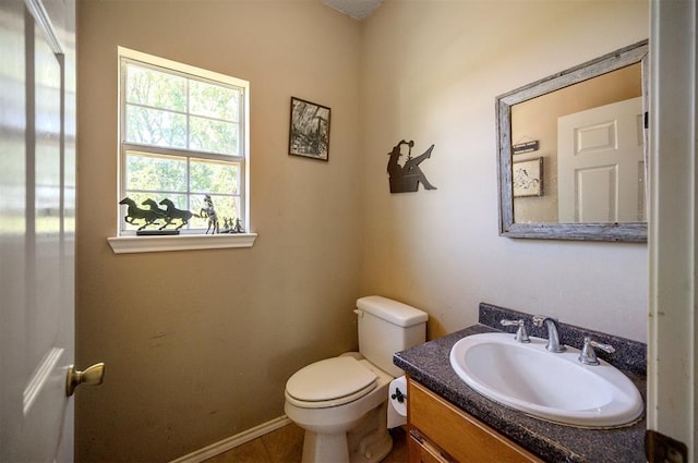 bathroom with baseboards, vanity, and toilet