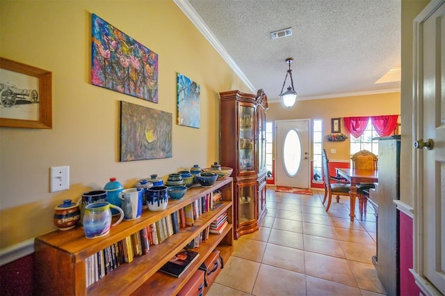 entrance foyer with visible vents, crown molding, a textured ceiling, and light tile patterned floors