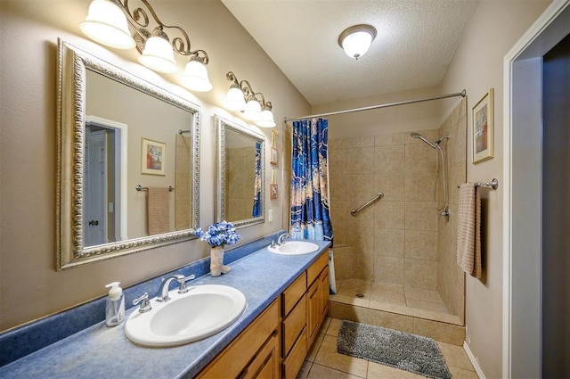 bathroom with double vanity, a sink, a tile shower, and tile patterned floors