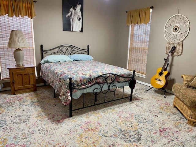 bedroom with baseboards and light colored carpet