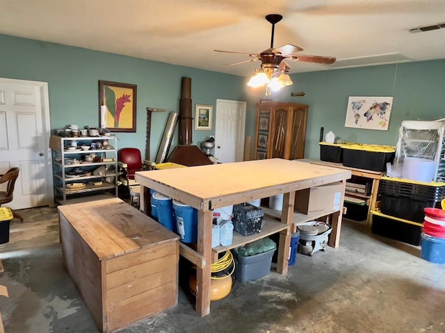 dining room featuring attic access, visible vents, concrete floors, and a ceiling fan