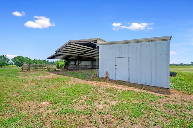 view of pole building with a yard and a rural view