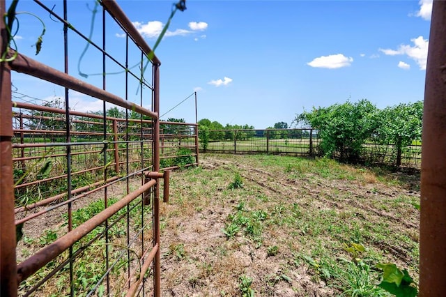 view of yard with an outbuilding, a rural view, and an exterior structure