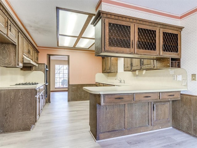 kitchen with a wainscoted wall, ornamental molding, and wallpapered walls