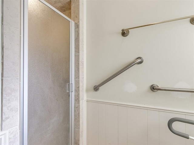 bathroom featuring wainscoting and a shower stall