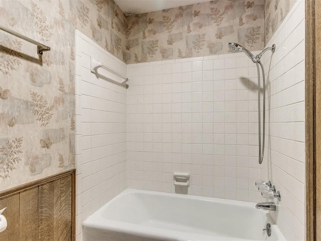 full bathroom with a wainscoted wall, shower / tub combination, and wallpapered walls