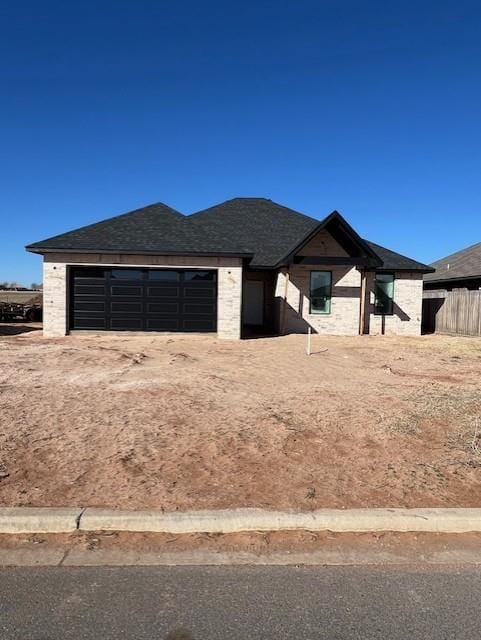 view of yard featuring driveway, an attached garage, and fence