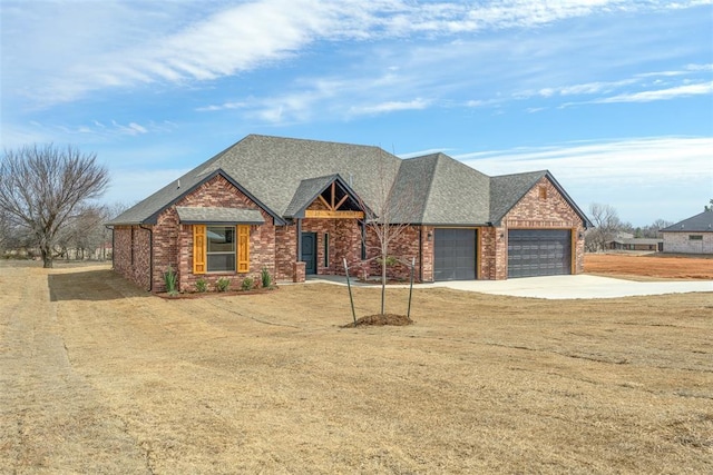 view of front of home featuring driveway, brick siding, an attached garage, and a shingled roof