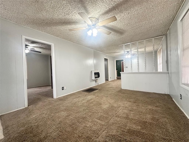 carpeted spare room featuring a textured ceiling, a ceiling fan, and heating unit