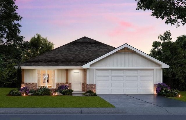 view of front of house featuring an attached garage, brick siding, a shingled roof, a yard, and driveway