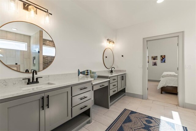 full bathroom featuring tile patterned flooring, two vanities, a sink, and a tile shower