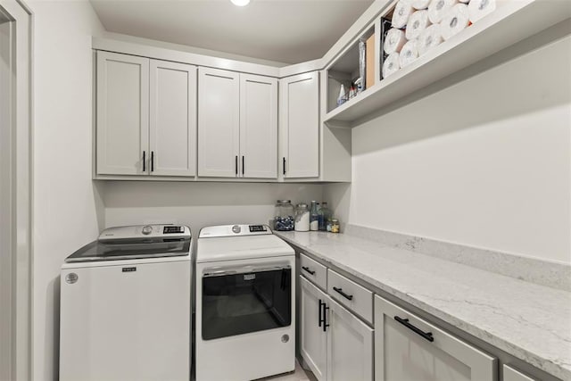 washroom with cabinet space and washing machine and clothes dryer