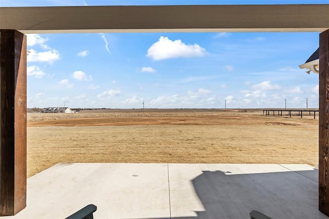 view of yard featuring a rural view and a patio