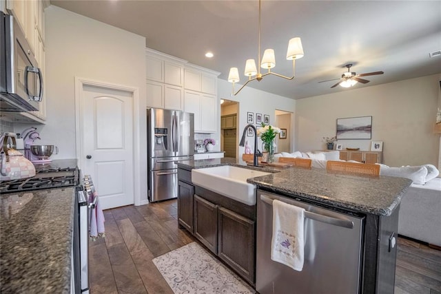 kitchen featuring dark wood-style floors, appliances with stainless steel finishes, open floor plan, a kitchen island with sink, and a sink