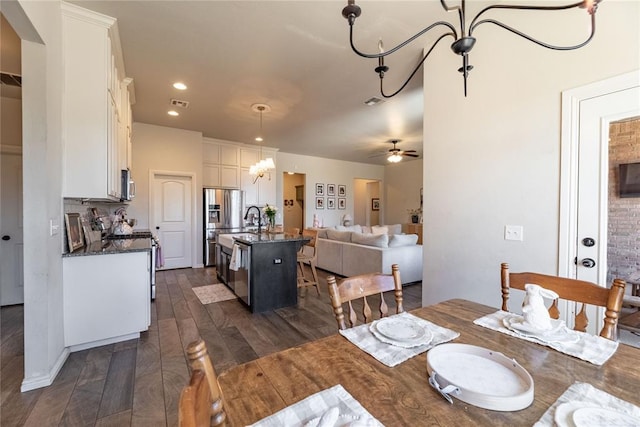 dining room featuring recessed lighting, visible vents, dark wood finished floors, and ceiling fan with notable chandelier