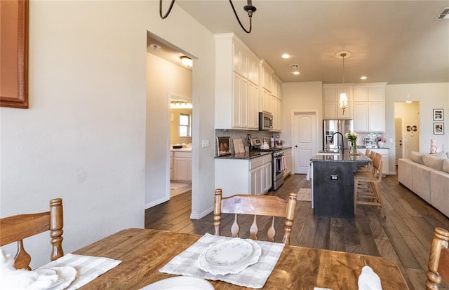 dining room featuring baseboards, dark wood-type flooring, visible vents, and recessed lighting