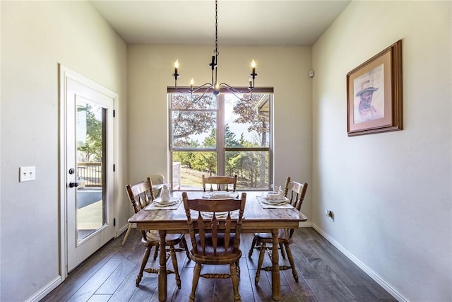 dining room featuring dark wood-type flooring, baseboards, and an inviting chandelier