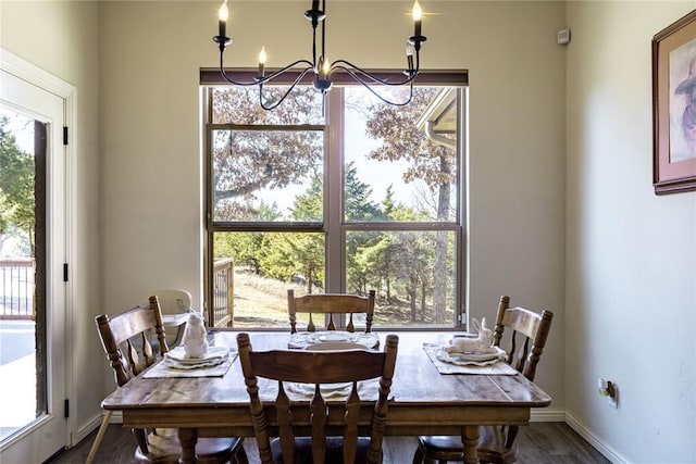 dining space with dark wood-style floors, baseboards, and a notable chandelier