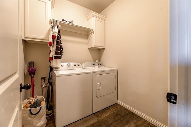 clothes washing area with dark wood-style flooring, independent washer and dryer, cabinet space, and baseboards