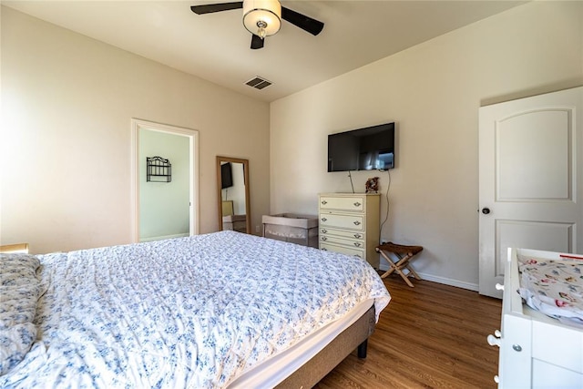 bedroom featuring a ceiling fan, baseboards, visible vents, and wood finished floors