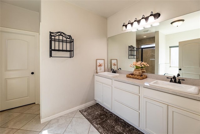 full bathroom with double vanity, a stall shower, tile patterned flooring, and a sink