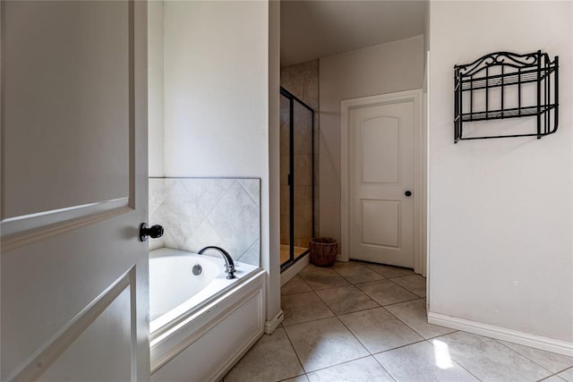 bathroom with tile patterned flooring, a shower stall, a bath, and baseboards