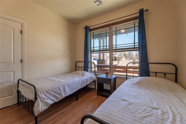 bedroom with visible vents and wood finished floors