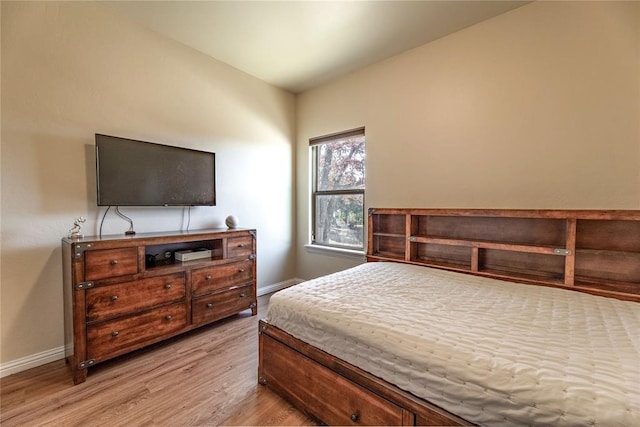 bedroom with baseboards and wood finished floors