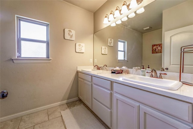 bathroom with double vanity, tile patterned flooring, baseboards, and a sink