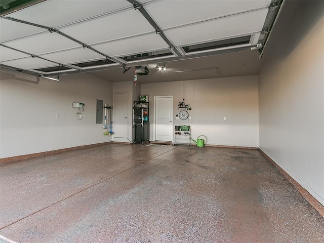 garage featuring baseboards, electric panel, and a garage door opener