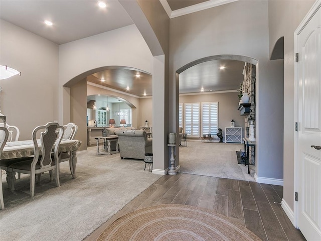 carpeted entryway featuring ornamental molding, wood tiled floor, and baseboards