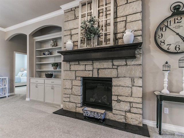 details with baseboards, built in features, ornamental molding, carpet, and a stone fireplace