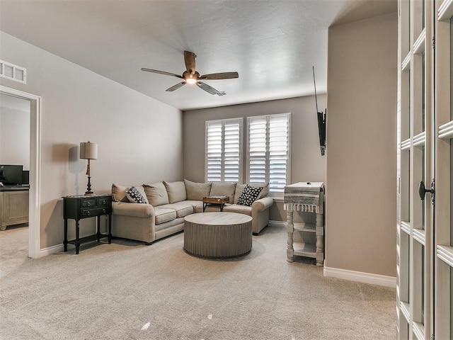 carpeted living area featuring ceiling fan, visible vents, and baseboards