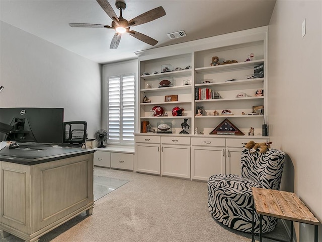 home office featuring light colored carpet, visible vents, and ceiling fan