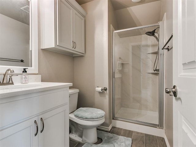 full bath featuring visible vents, toilet, a shower stall, vanity, and wood finished floors