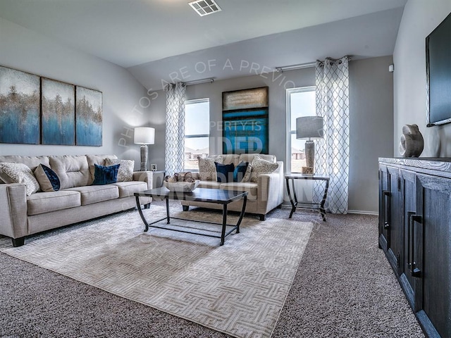 living area with carpet, visible vents, and vaulted ceiling