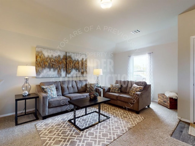 carpeted living area featuring baseboards and visible vents